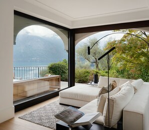 A modern living room with a large window, a sofa, and a coffee table. - Villa Magnifica by My Villa Collection (Lenno)