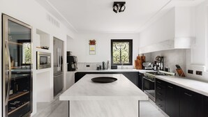 Una cocina moderna con una isla central, electrodomésticos de acero inoxidable y un ventanal grande.