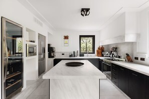 A modern kitchen with a central island, stainless steel appliances, and a large window. - Villa Magnifica by My Villa Collection (Lenno)