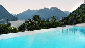 Una piscina con vistas a montañas y un lago.