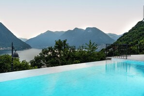 Ein Schwimmbad mit Blick auf Berge und einen See.