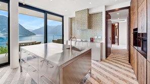 Una cocina moderna con una isla grande, vista al mar y un salpicadero con diseño.