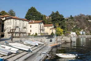 A waterfront property with a dock, boats, and buildings with balconies. - Villa la Petite by My Villa Collection (Lenno)