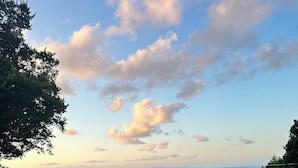 Ein Schwimmbad mit Blick auf das Meer und einen Sonnenuntergang.