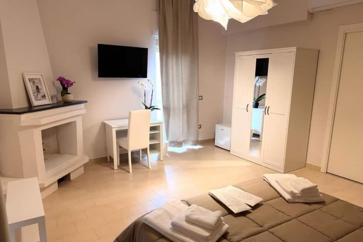 Un dormitorio con cama, escritorio, silla y armario.