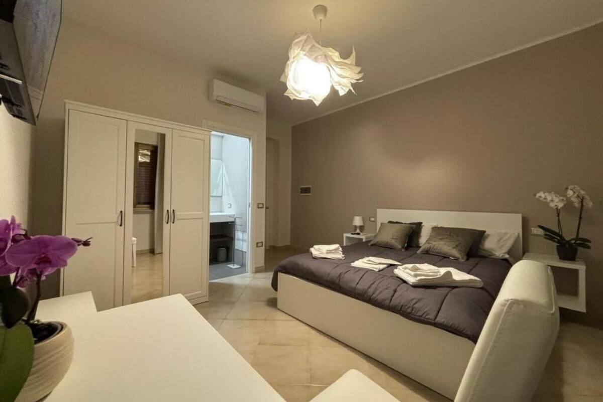 Un dormitorio con cama, mesita de noche y lámpara en el techo.
