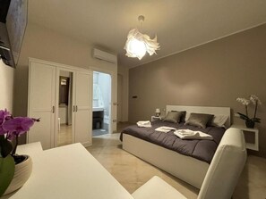 Ein Schlafzimmer mit Bett, Nachttisch und einer Deckenleuchte.