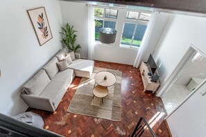 Un salon moderne avec un canapé, une table basse et un téléviseur.