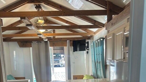 Een compact camperinterieur met een kitchenette, een eethoek en een slaapgedeelte.
