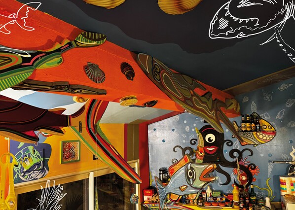 A vibrant room with colorful artwork, a fish-themed wall, and various decorative items. - LE PULPICOOL (Sète)