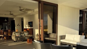 An open-plan living area with a dining set, a sofa, and wicker furniture. - Hacienda Iguana Beachfront 3BR · Surf & Sunset (Tola)