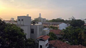 A residential area with various buildings, including a modern white structure and traditional houses with red-tiled roofs. - Private bedroom with ensuite bathroom in Colombo 5 (Colombo)
