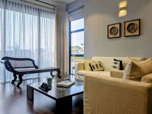 A modern living room with a sofa, a bench, and a coffee table. - 2 Bedroom Apartment in Colombo 05 (Colombo)
