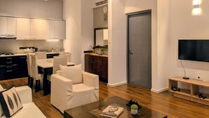A modern living room with a dining area, a kitchen, and a TV. - 2 Bedroom Apartment in Colombo 05 (Colombo)