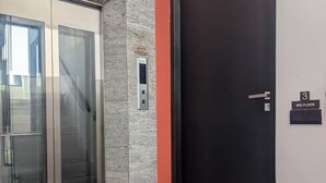 A modern elevator with a glass door, a wall-mounted attention sign, and a door with a number indicating the 3rd floor. - 2 Bedroom Apartment in Colombo 05 (Colombo)