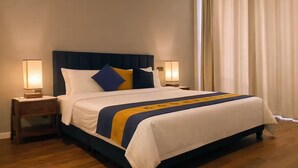 A hotel room with a bed, two bedside tables with lamps, a window with curtains, and a wooden floor. - 2 Bedroom Apartment in Colombo 05 (Colombo)