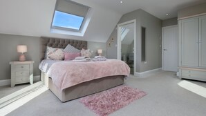 A bedroom with a bed, a skylight, a wardrobe, and a mirror. - Tan-Y-Foel (Dyffryn Ardudwy)