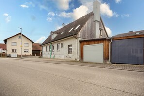 Eine Wohnstraße mit Häusern, einer Garage und einem Schild für 3D-Parken.