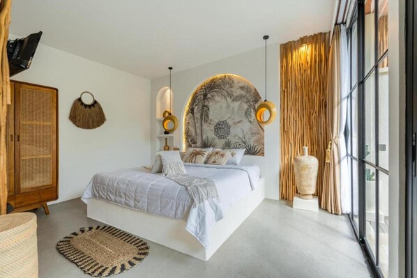A modern bedroom with a large bed, a rattan wardrobe, and a large window with curtains. - Maha Villa Ubud (Sukawati)