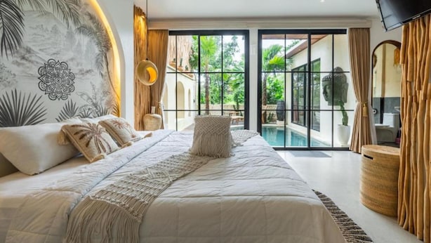 A bedroom with a large bed, a view of a swimming pool, and a TV mounted on the wall. - Maha Villa Ubud  (Sukawati)