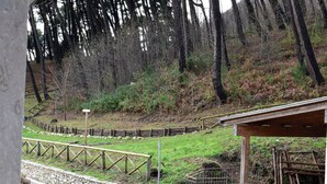 A stone wall, wooden fence, and a covered area with a bench. - Dimora San Martino (Monteforte Irpino)