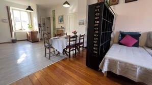 A room with a bed, a dining table with chairs, and a bookshelf. - The house on the harbor, Major: central, partial lake view, parchegggio (Mombello)
