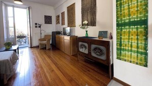 A spacious room with wooden flooring, a dining area with a table and chairs, a kitchenette with cabinets, and decorative wall hangings. - The house on the harbor, Major: central, partial lake view, parchegggio (Mombello)