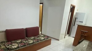 Un amplio salón con sofá, una mesa de comedor y una cocina al fondo.