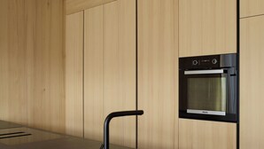 Una cocina moderna con horno empotrado y un elegante lavamanos negro.