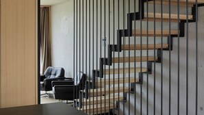 Un interior moderno con una escalera, un escritorio y una silla.