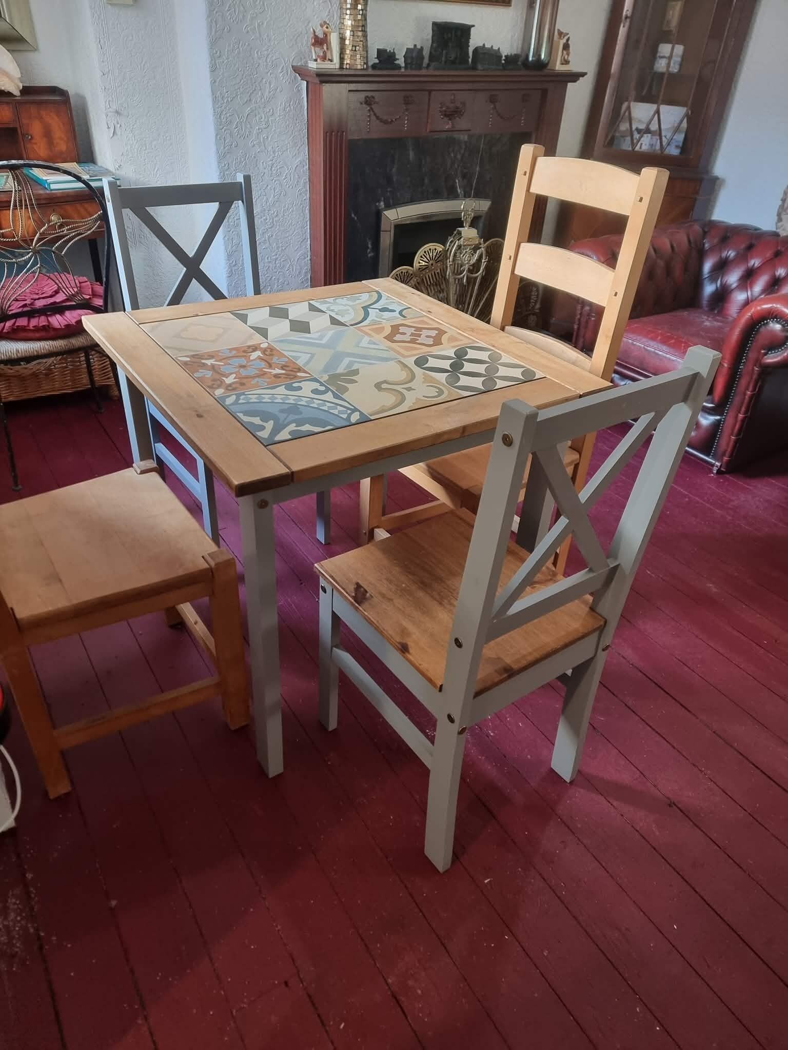 Et spiseområde med et træbord, stole, en pejs og en rød lædersofa.