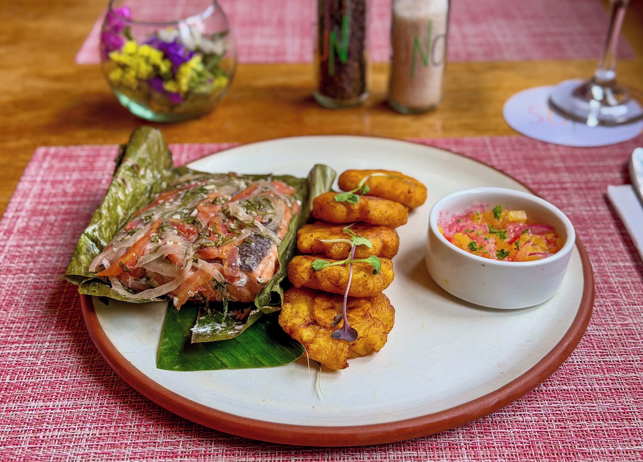 Une assiette contenant du poisson, des aliments frits et une sauce pour tremper.