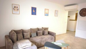 Una sala de estar con un sofá, una mesita y un reloj en la pared.
