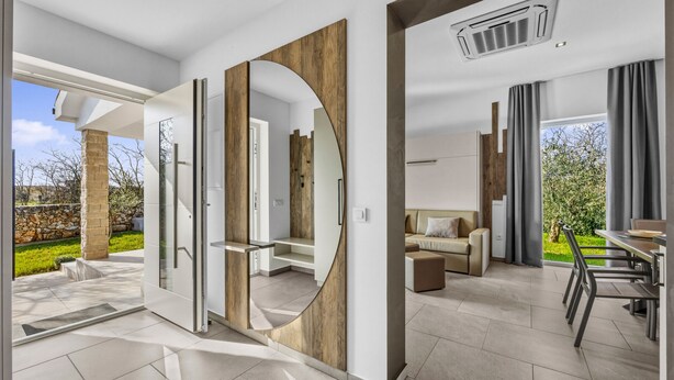 A modern interior with a large mirror, a dining area, and a view of the outdoors. - Lavanda Harmony Apartment (Pomer)