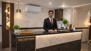 A reception desk with a marble countertop, a 'Welcome' sign, and a 'RECEPTION' label. - Shahenshah Hotel  (Prayagraj)