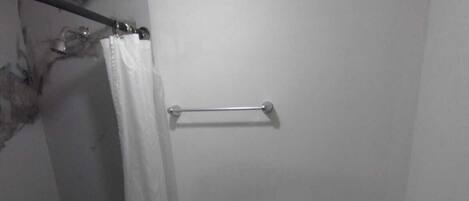 A small, compact bathroom with a toilet, sink, and shower area.