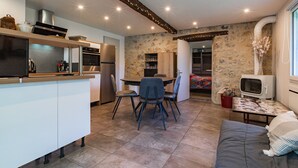 Une cuisine moderne avec un coin repas, un canapé et un téléviseur.