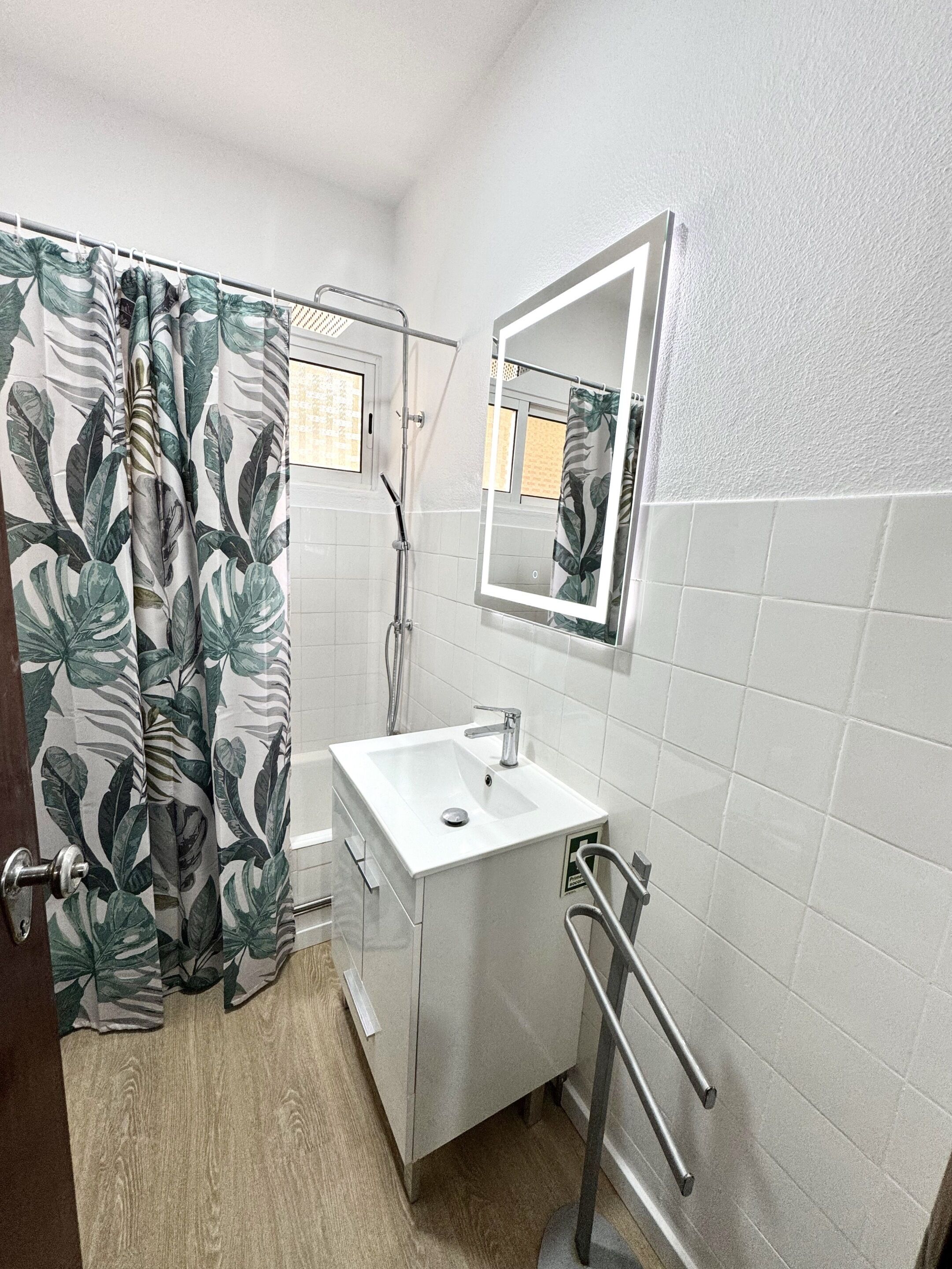 A bathroom with a shower, a sink, a mirror, and a toilet.