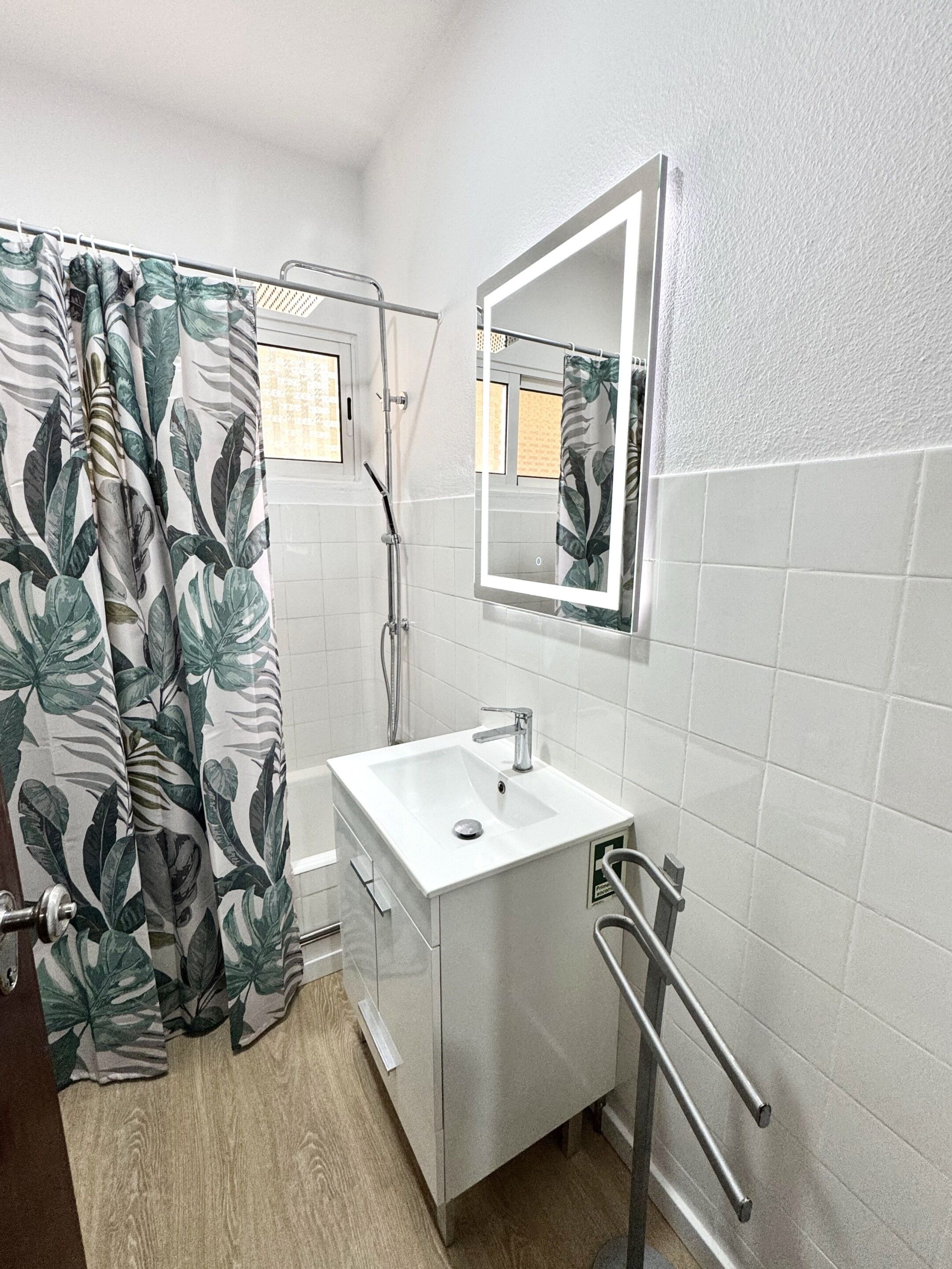 Un baño con ducha, lavabo, espejo e inodoro.