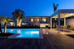 A modern house with a swimming pool, outdoor seating, and a well-maintained garden. - Amalfi Home – Relax near the sea with private beach and shuttle to Salerno (Pontecagnano)