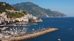 Un pueblo costero con edificios históricos, un puerto deportivo y una costa rocosa.