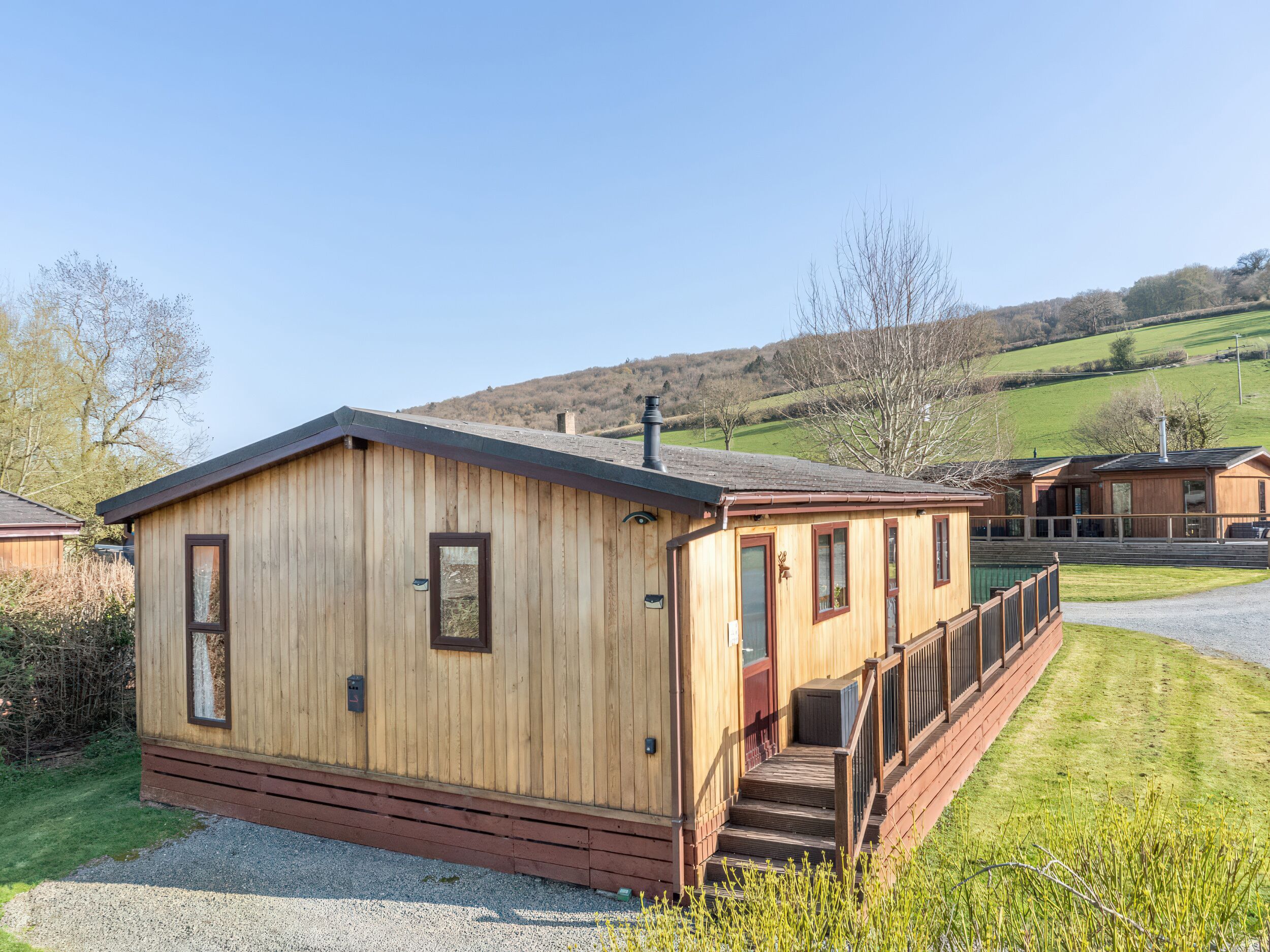 Eine Holzhütte mit einer Veranda und Stufen, die zu einer Tür führen.