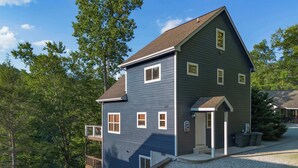A two-story house with a balcony, a garage, and a driveway. - Lakefront Home w/Private Dock, Hot Tub (LaFollette)