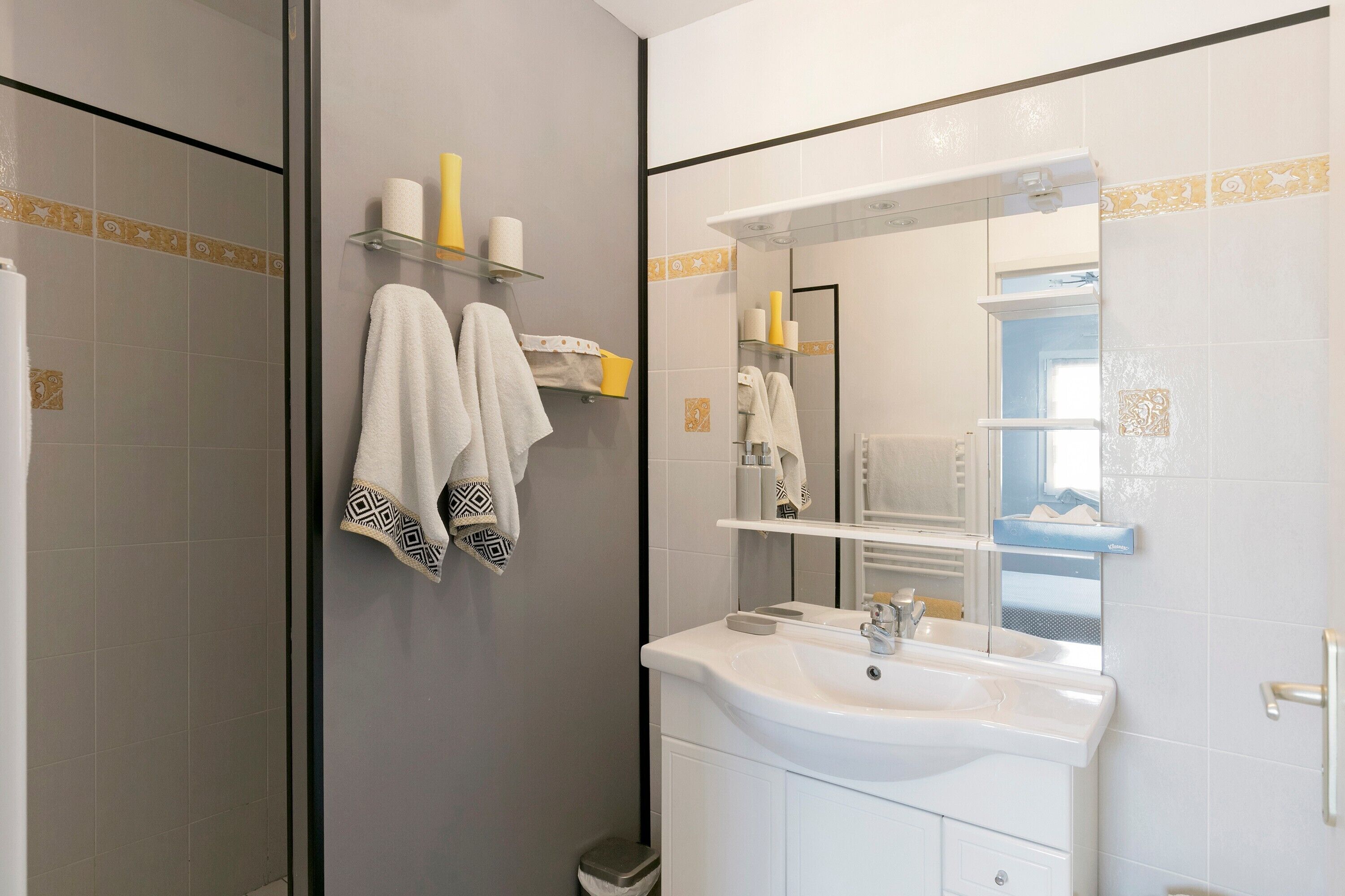 A bathroom with a sink, mirror, and towel rack.
