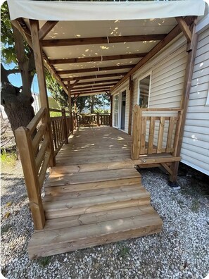 A wooden deck leading to a covered porch with a pergola overhead. - Mobile home camping siblu lac des rêves (Lattes)