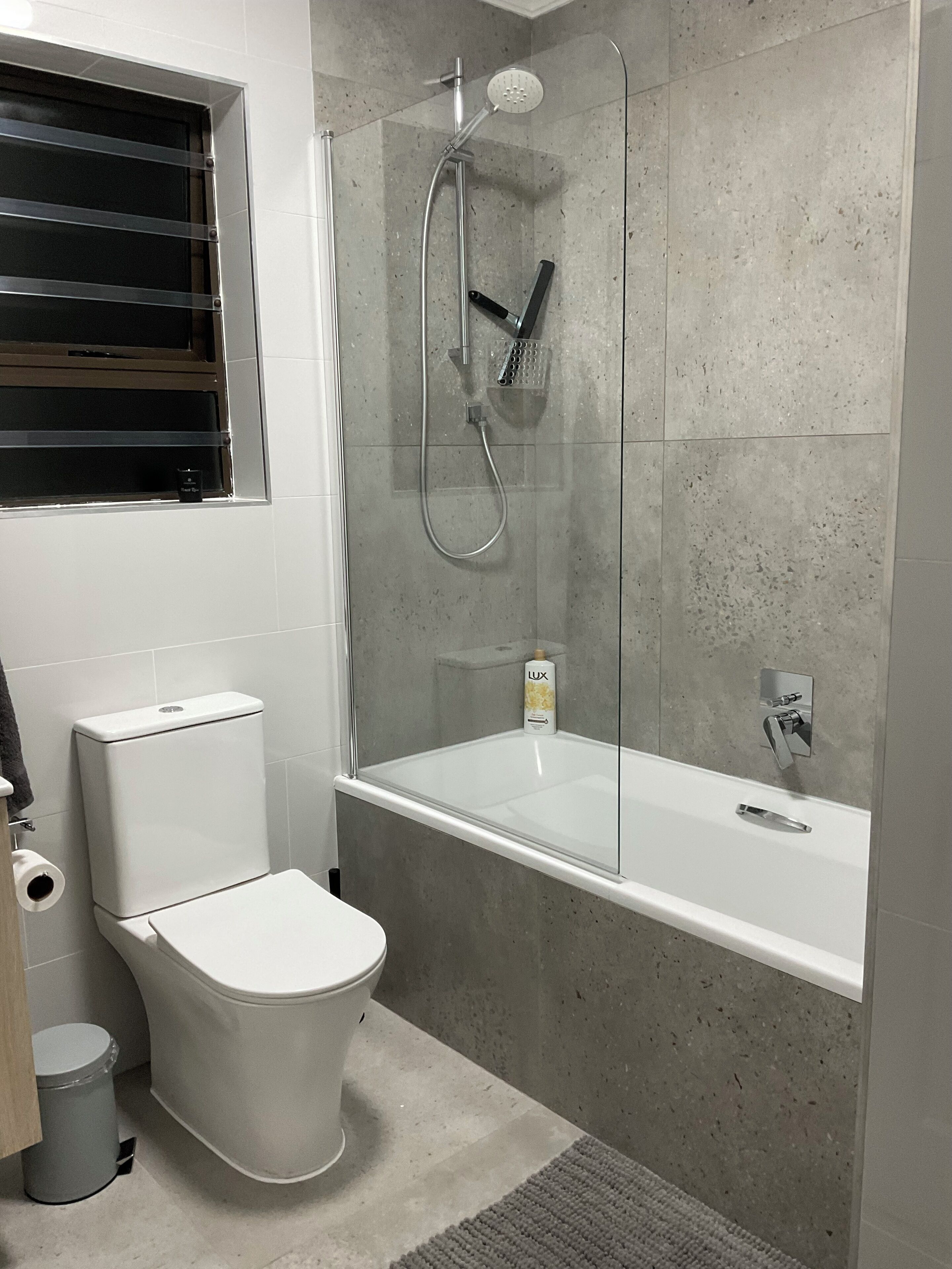 Un baño moderno con inodoro, cabina de ducha y bañera.