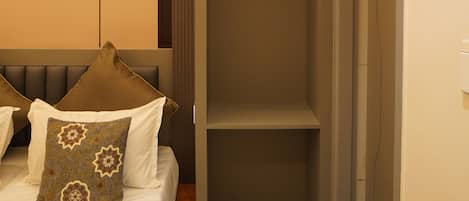 Una camera da letto con un letto, un comodino, un armadio e scaffali a muro.