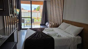 A hotel room with a bed, a desk, and a view of the outdoors. - Acqua Beach Flat Tamandare by la Playa (Tamandaré)