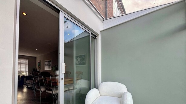 A modern interior with a sliding glass door leading to a dining area. - NEC Solihull Home | Parking, Garden, JLR & Airport (Solihull)