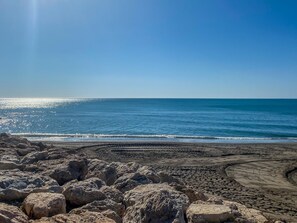 A beach with large rocks in the foreground and a clear blue sky. - Casa Marta - Seaviews (Torremolinos)